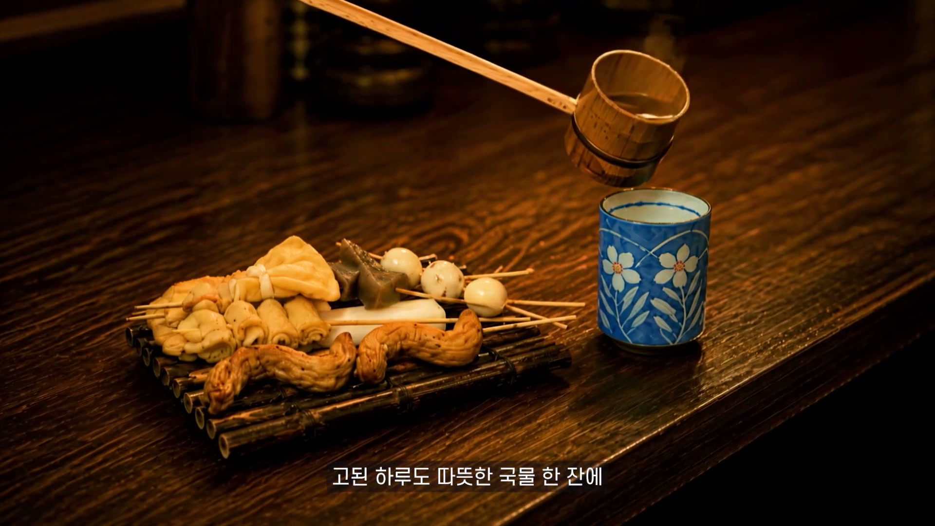 오뎅과 따뜻한 국물이 놓인 나무 테이블